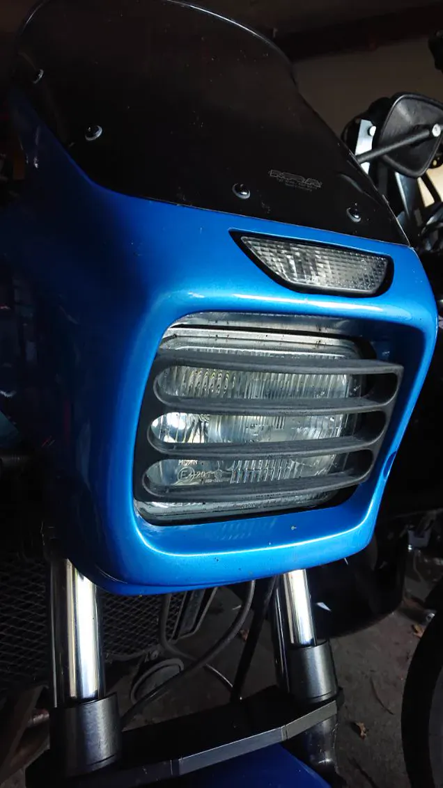 Grille de phare imprimée en 3D, peinte en bleu, montée sur le carénage d'une moto